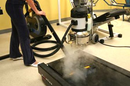 Image showcasing the use of Duplex Cleaning Machines' Jetvac Steam Cleaner for thermally cleaning and deodorising treadmill surfaces in gym environments, enhancing hygiene beyond standard cleaning.