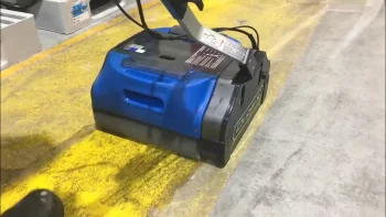 A floor scrubber is cleaning the floor in a warehouse.