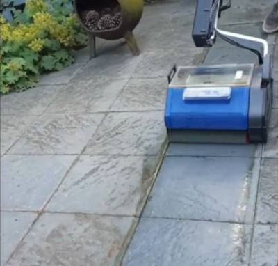 Outdoor marble surface being cleaned with a Duplex floor machine in a garden area.