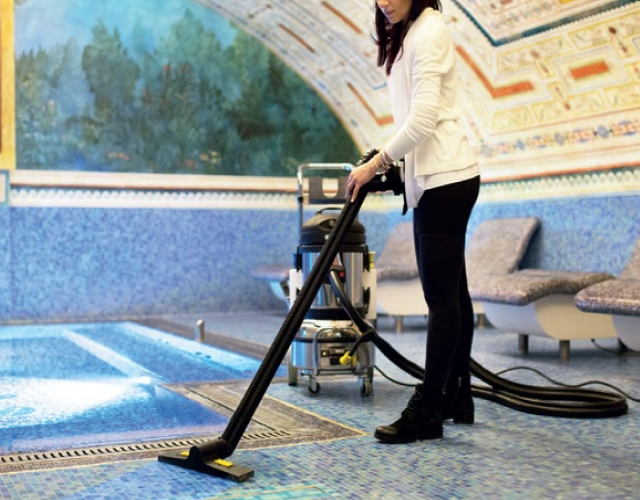 Using a steam cleaner to sanitise tiled spa area in hotel accommodation.