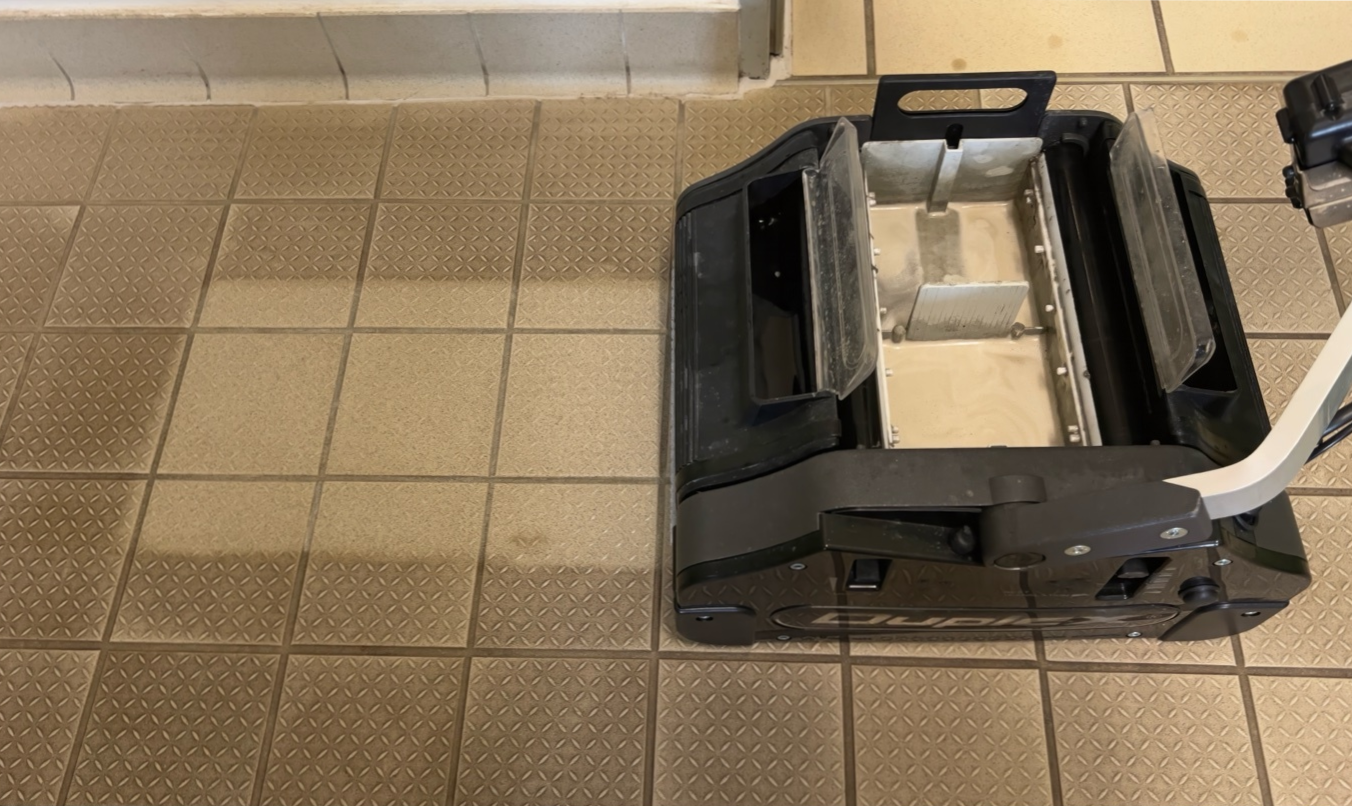 Duplex 420 commercial floor scrubber cleaning textured safety floor tiles, showing clear before and after results.
